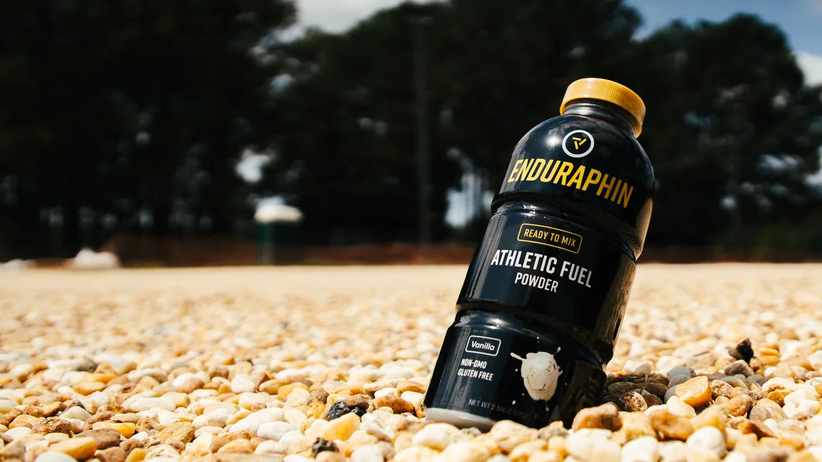 Enduraphin Athletic Fuel bottle in a field setting